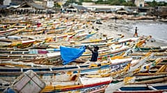 Ein Fischer trocknet ein Tuch neben den Fischerbooten in Dakar, Senegal, 30.07.2020