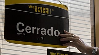 El cartel de cerrado cuelga sobre la puerta de una oficina de la Western Union