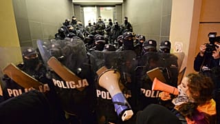 People block access to a police station where a few demonstrators are being detained after a pro-choice demonstration in Warsaw in Warsaw, Poland, Monday Nov. 23, 2020.