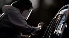 An employee takes a smear sample for a new coronavirus COVID-19 test  in Nuertingen, Germany, Wednesday, Nov 25, 2020. 