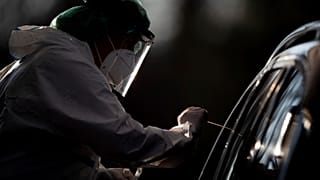 An employee takes a smear sample for a new coronavirus COVID-19 test  in Nuertingen, Germany, Wednesday, Nov 25, 2020. 