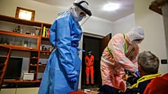 Medical staffer Ruggero Gariboldi, right, measures oxygen level in the blood of a suspected Covid patient