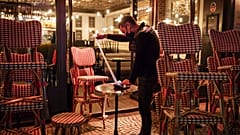 A waiter checks the final revenue as he closes a bar terrace in Paris, Saturday, Oct. 17