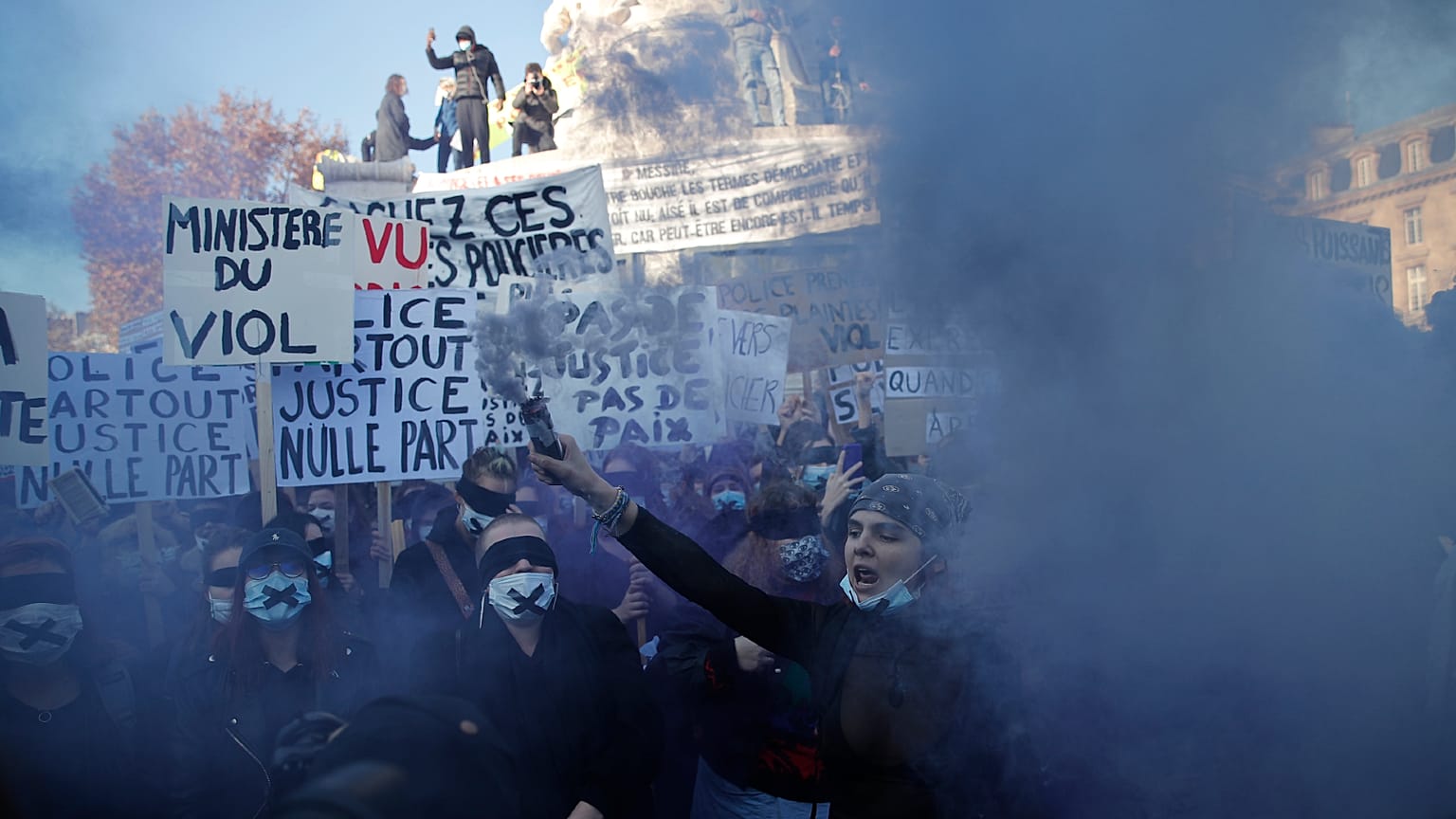 A protester holds a flare during a demonstration security law that would restrict sharing images of police, Saturday, Nov. 28, 2020 in Paris