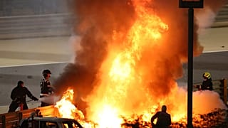 Staff extinguish French driver Romain Grosjean's car after a crash during the Formula One race in Bahrain, Nov 29, 2020.