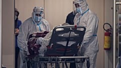 Medical personnel transfer a COVID-19 patient from a state to a private clinic which has been appropriated, in the northern city of Thessaloniki