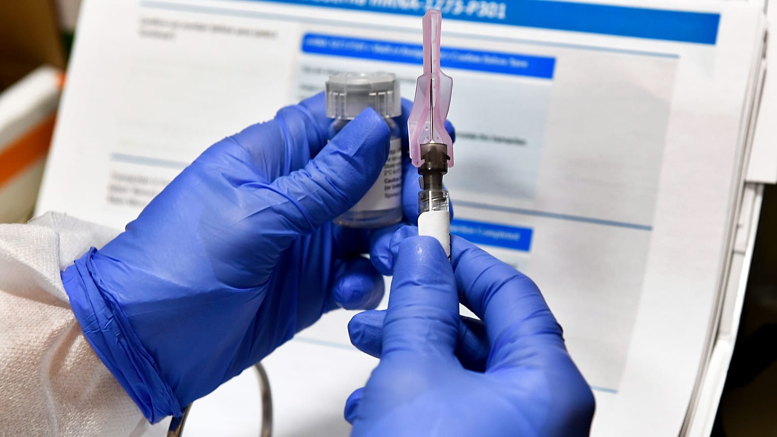 FILE - In this July 27, 2020, file photo, nurse Kathe Olmstead prepares a shot that is part of a possible COVID-19 vaccine.