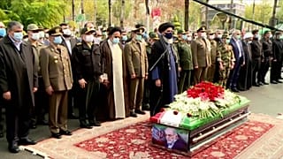 People praying in front of the coffin