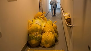 A medical worker passes by contaminated waste products in a hallway outside the intensive care ward for Covid-19 patients at the MontLegia CHC hospital in Liege.