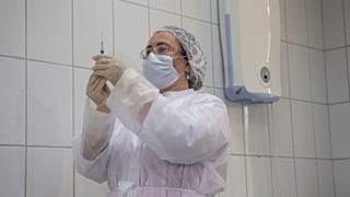 Orosz egészségügyi dolgozó készül a Sputnik V oltás beadására egy tesztalanynak