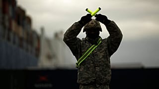 A U.S. soldier directs armoured vehicles and tanks of the 1st Armored Brigade Combat Team and 1st Calvary Division at the port of Antwerp, Belgium, Nov. 16, 2020.