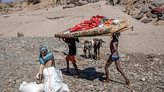 Tigray refugees who fled the conflict in the Ethiopia's Tigray carry their furniture in Hamdayet, eastern Sudan, Tuesday, Dec. 1, 2020. (AP Photo/Nariman El-Mofty)