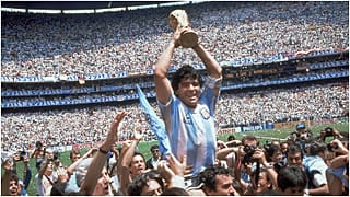مارادونا يحمل كأس العالم التي فاز بها منتخبه الأرجنتين عام 1986
