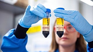 In this undated file photo issued by the University of Oxford a researcher works on the coronavirus vaccine  developed by AstraZeneca and Oxford University.