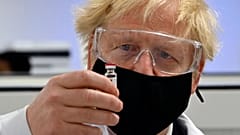 Il premier britannico Boris Johnson posa con una fiala del vaccino anti Covid