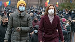 Moldova's president elect Maia Sandu, right, walks away after addressing protesters outside the parliament building in Chisinau, Moldova, Thursday, December 3, 2020.
