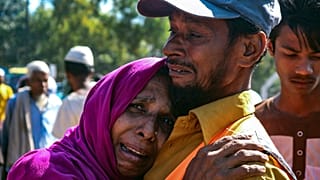 Una rifugiata Rohingya piange fuori da un'area di transito, dove sono temporaneamente ospitati a Ukhiya, Bangladesh