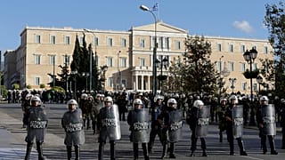 Riot police block the road outside luxury hotels