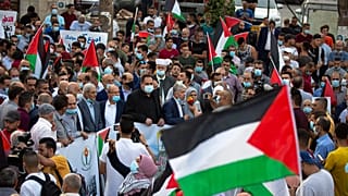 فلسطينيون يلوحون بالأعلام احتجاجاً على تطبيع العلاقات بين الإمارات العربية المتحدة والبحرين مع إسرائيل، رام الله بالضفة الغربية