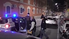 A suspect is led away by police
