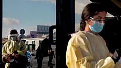 A health worker, left is reflected in a door of a building as he carries out a rapid coronavirus test, on a main avenue in Strovolos in Nicosia