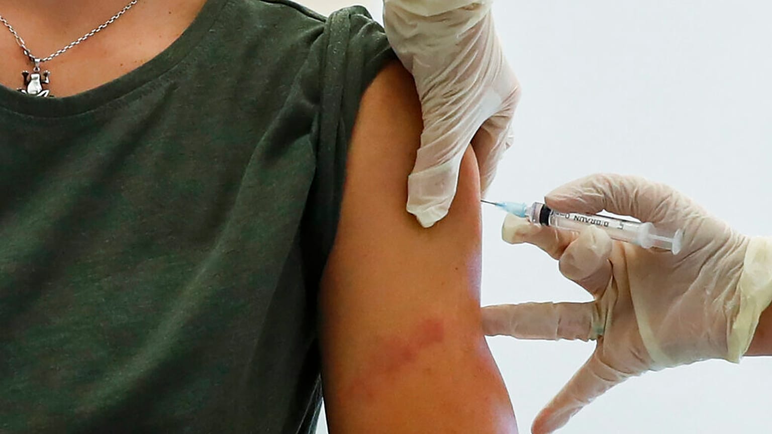A Russian medical worker, right, administers a shot of Russia's Sputnik V coronavirus vaccine in Moscow, Russia, Saturday, Dec. 5, 2020. 