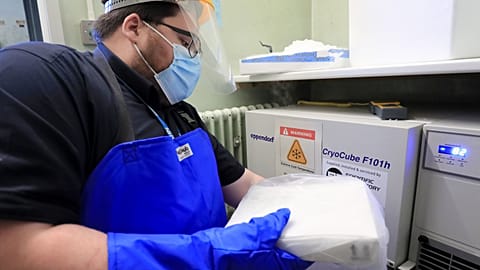 A pharmacy technician from Croydon Health Services takes delivery of the first batch of COVID-19 vaccinations at Croydon University Hospital in south London.