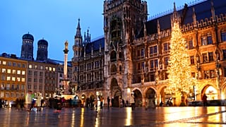 People wearing face masks in front of a giant Christmas tree at the famous 'Marienplatz' in Munich