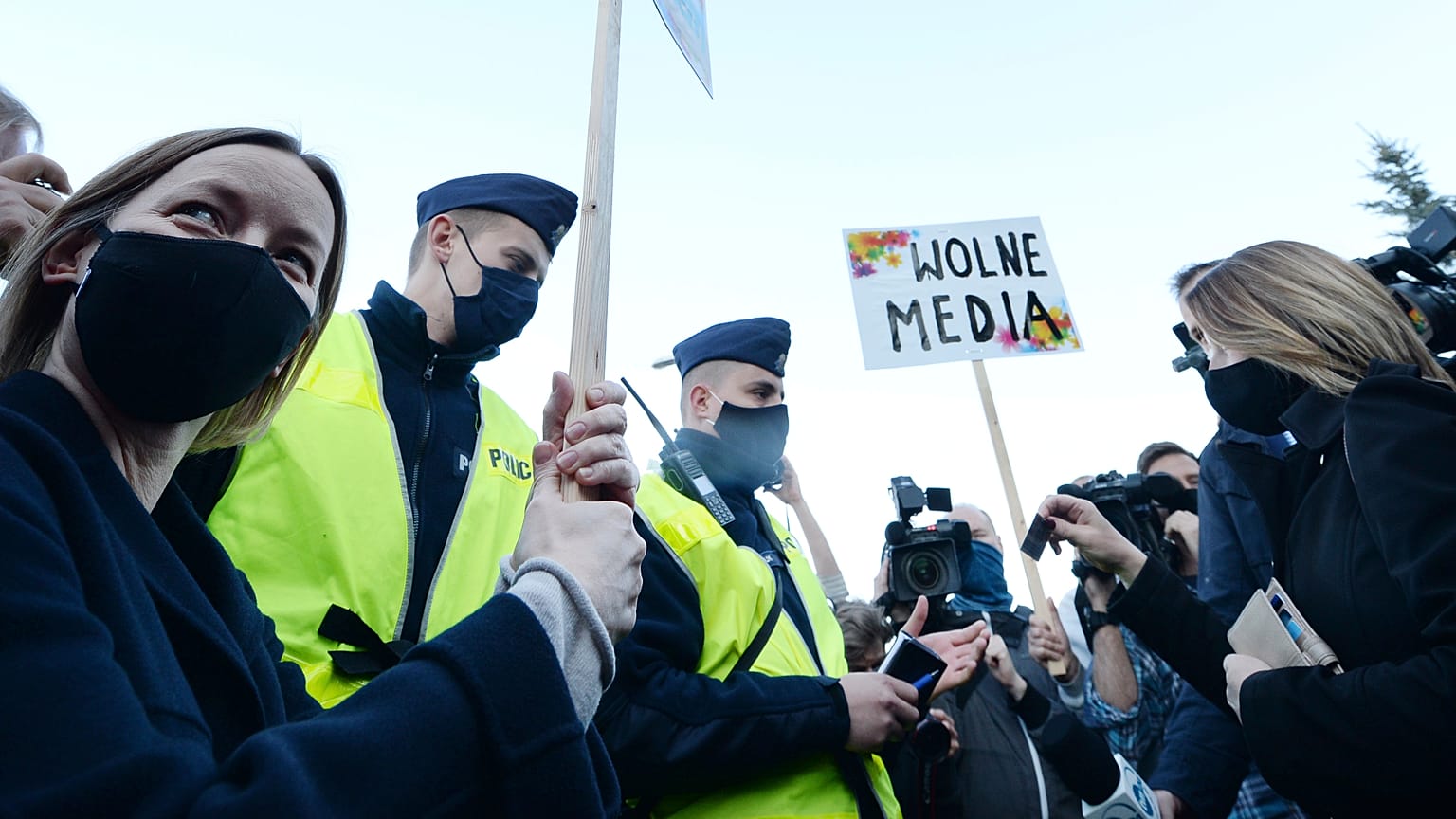 A protester holds a banner that reads: "Free Media", during a protest outside the Polish state-run radio station Radio Trojka, in Warsaw, Poland, Friday, May 22, 2020.