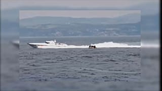 Boot der türkischen Küstenwache und Boot mit Migranten.