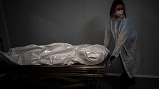 نقل جثة مسن توفي بسبب كوفيد-19 في دار لرعاية المسنين في برشلونة، إسبانيا.