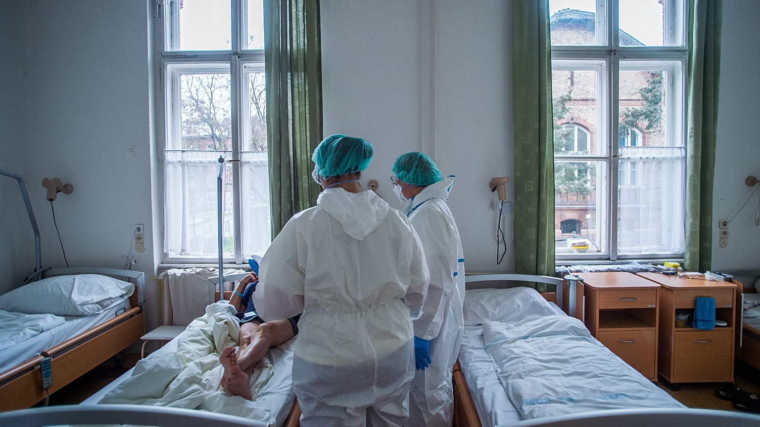Védőfelszerelést viselő orvosok vizitelnek a koronavírussal fertőzött betegek fogadására kialakított intenzív osztályon a Szent János Kórházban 2020. december 9-én.