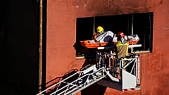 Firefighters load the body of a dead person into a crane after a fire on a building in Badalona, Barcelona, Spain, 