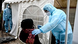 Medical personnel take a smear in the entrance area of the nightclub "KitKat-Club" for a rapid antigen test in Berlin, Germany, Oct. 9, 2020. 