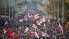 People with old Belarusian national flags march during an opposition rally to protest the official presidential election results in Minsk, Belarus, Sunday, Oct. 18, 2020