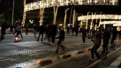 Protesters throw stones to riot police during clashes in Tirana