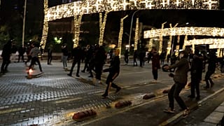 Protesters throw stones to riot police during clashes in Tirana