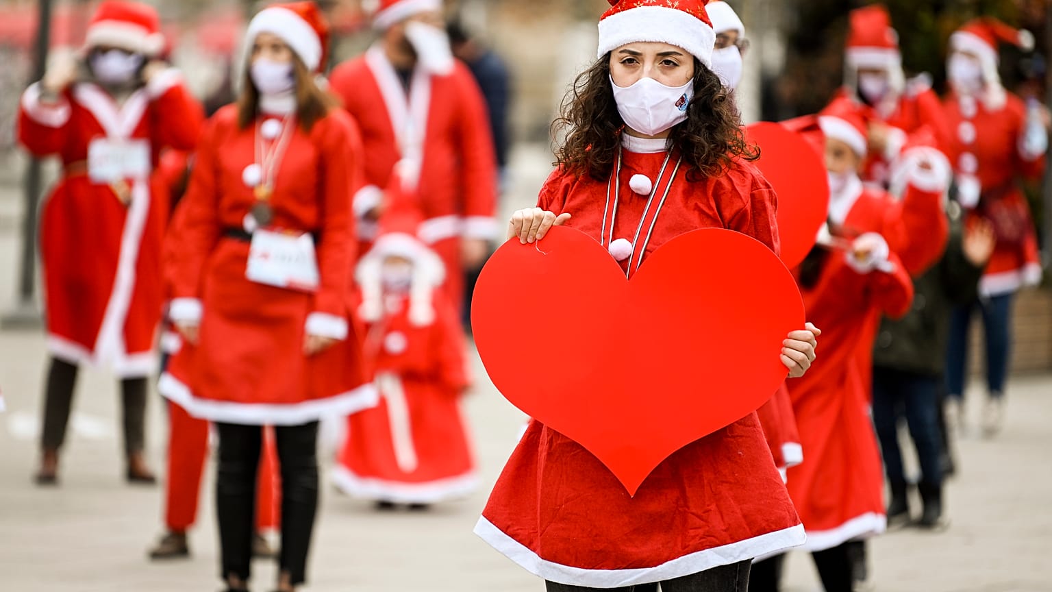 People dressed as Santa Claus take part in a charity event in Pristina.