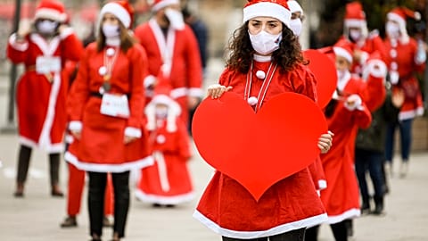 People dressed as Santa Claus take part in a charity event in Pristina.