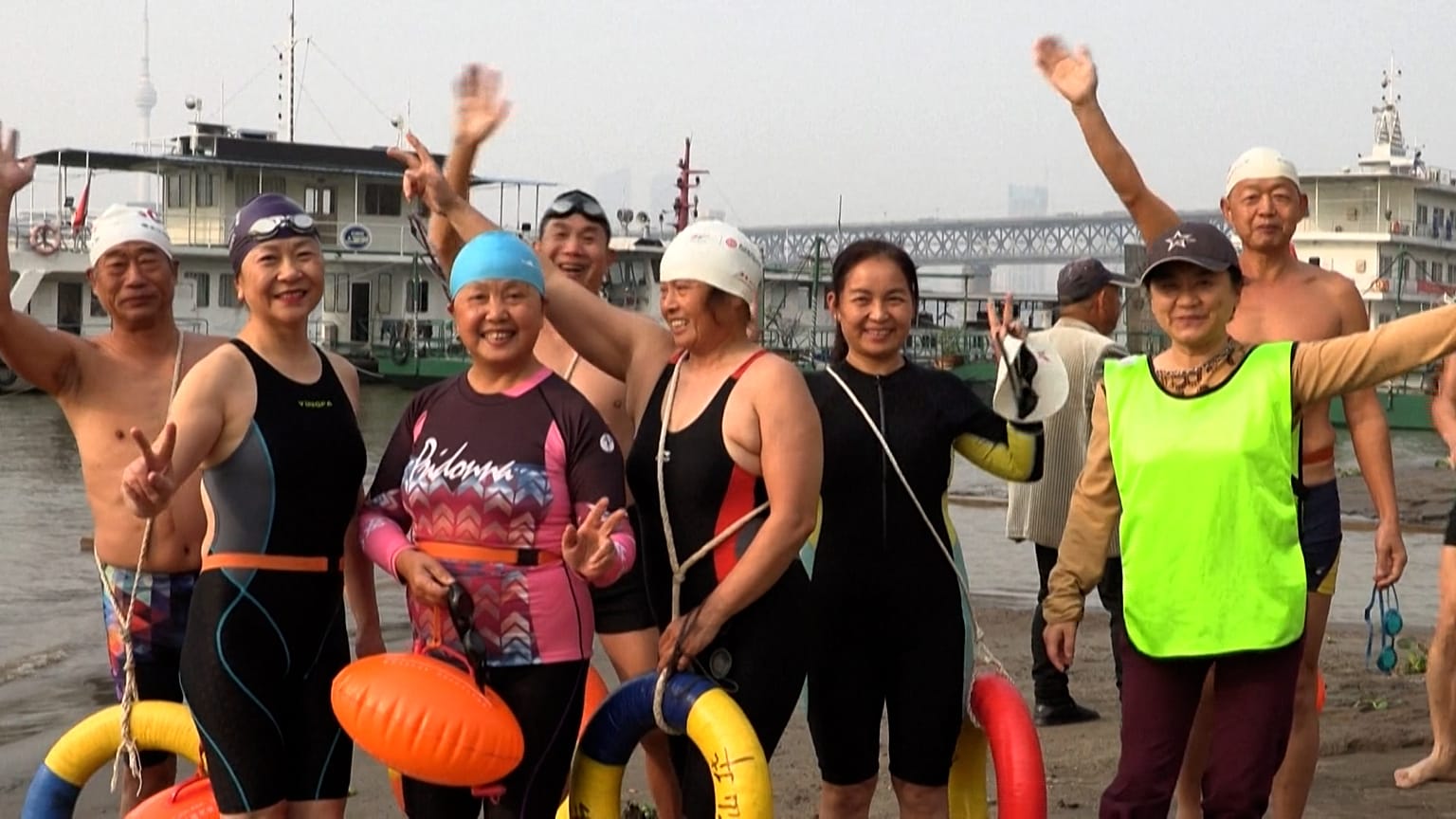 Swimmers waving hands to the camera