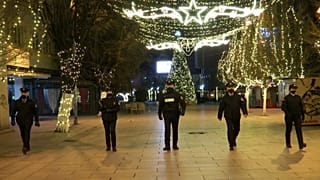 Police officers walking while patrolling empty boulevard