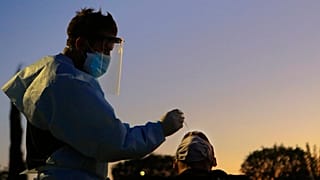 A health worker carries out a rapid coronavirus test at a car-parking in Lakatamia a suburb west of capital Nicosia