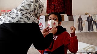 كمامات بألوان الميلاد مطرزة بأيدي مريضات سرطان في غزة