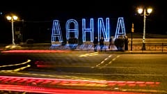 Light tracks of passing cars are seen in front of a Christmas installation in Athens