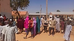 Mehrere Menschen versammeln sich vor der von den Islamisten angegriffenen Schule