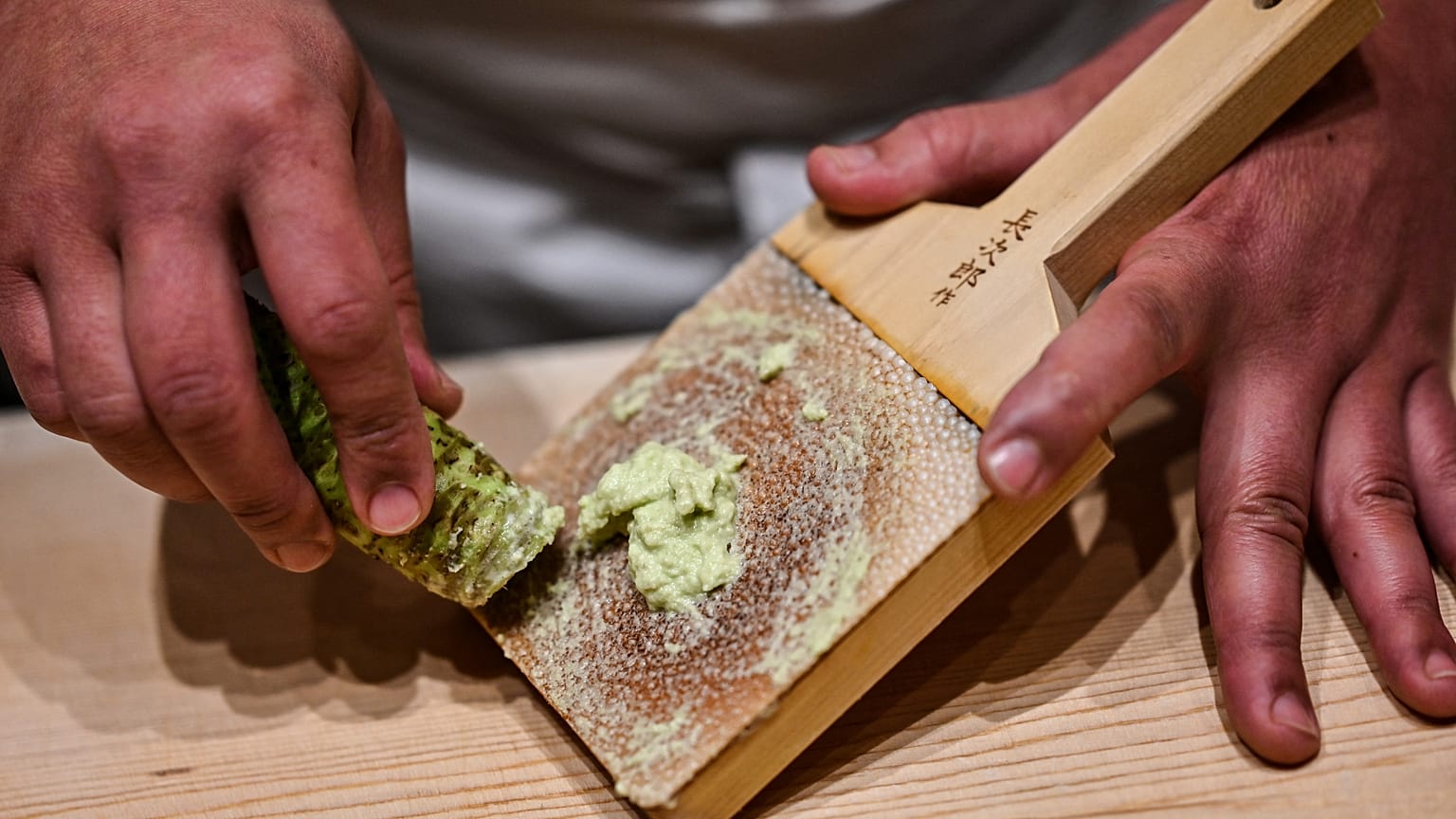 Sushi-Koch Toshiya Matsushita bereitet frischen Wasabi zu