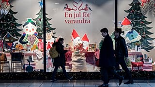 People walk past a Christmas themed shop window in central Stockholm, Sweden, Tuesday Nov. 10, 2020.