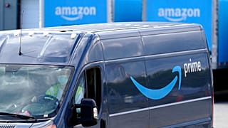 Csomagokat szállító furgon indul az Amazon raktárából a Massachusetts állambeli Dedham városában