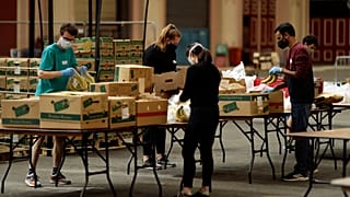 Volunteers check the quality of donated food to be put in packs delivered to residents who need it in the Haringey Council area, London, April 2020.