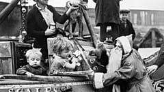 21 dicembre 1938: un uomo vestito da Babbo Natale distribuisce giocattoli ai bambini che secondono da una chiatta nel porto di Brentford, Regno Unito